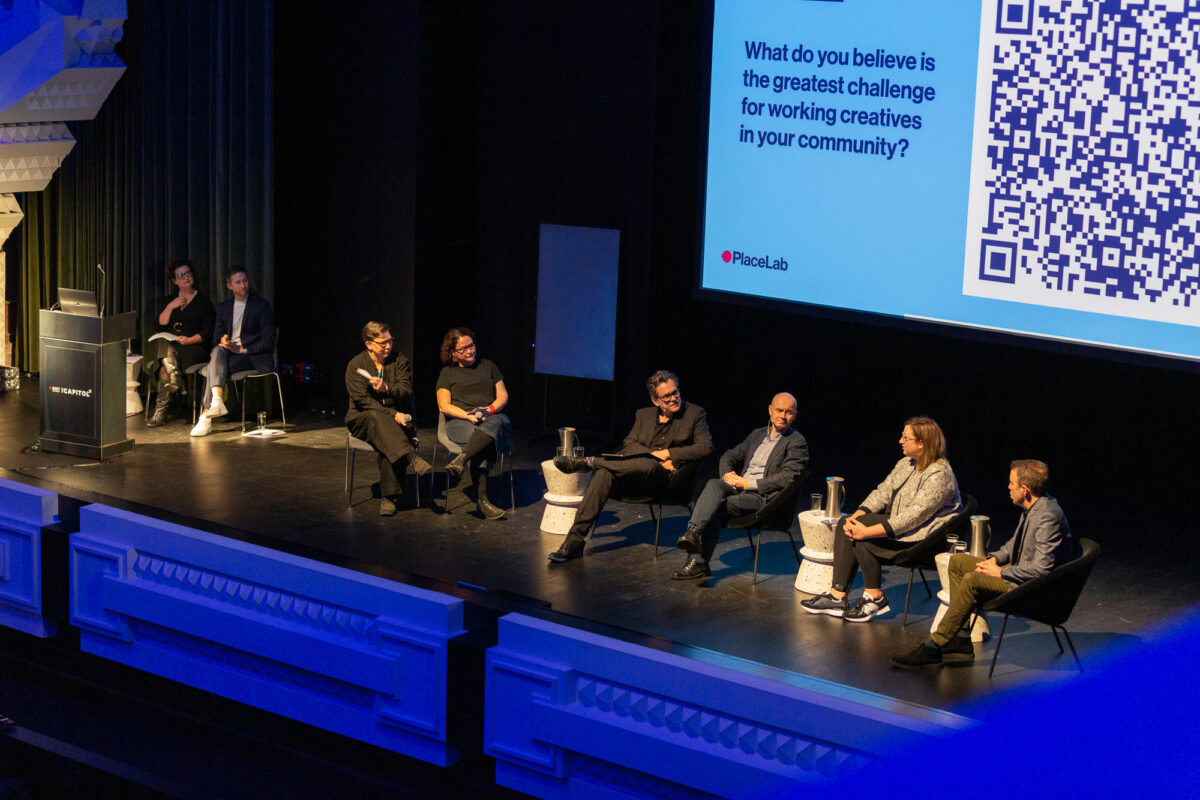 A panel discussion sits on the stage at the Capitol venue.