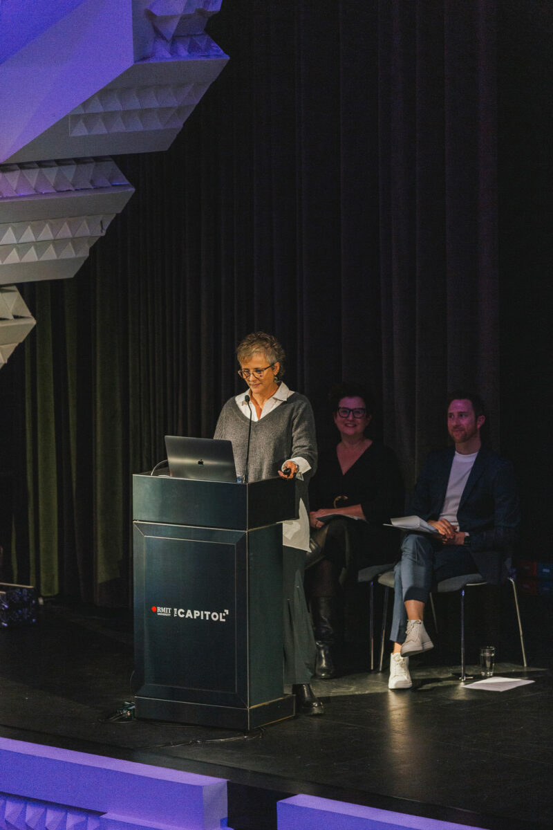 A woman gives a speech at the podium at the Capitol Theatre.