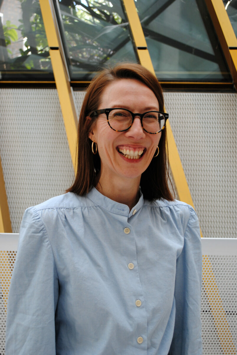 A woman smiling with glasses.