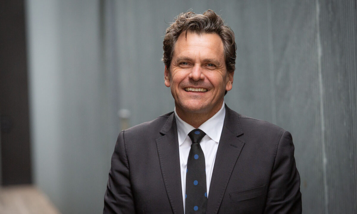 A smiling man wearing a suit and tie.