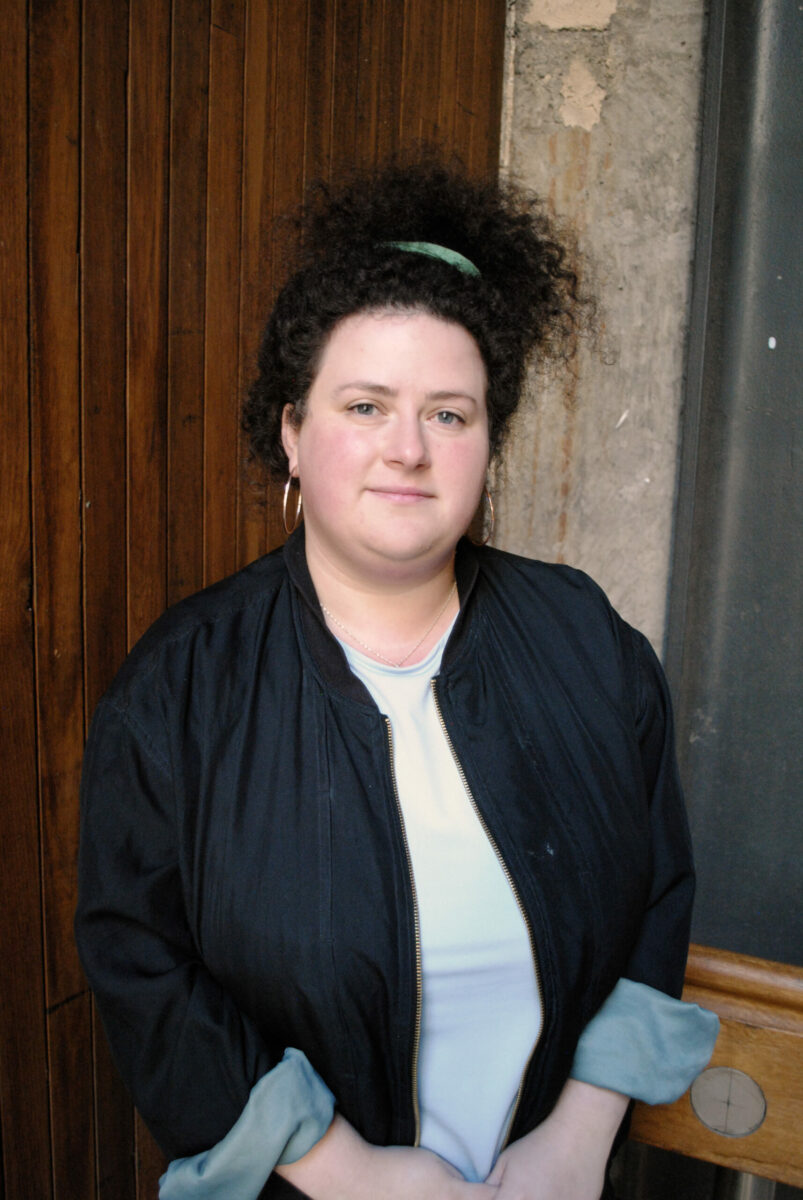 A woman smiling with curly hair.