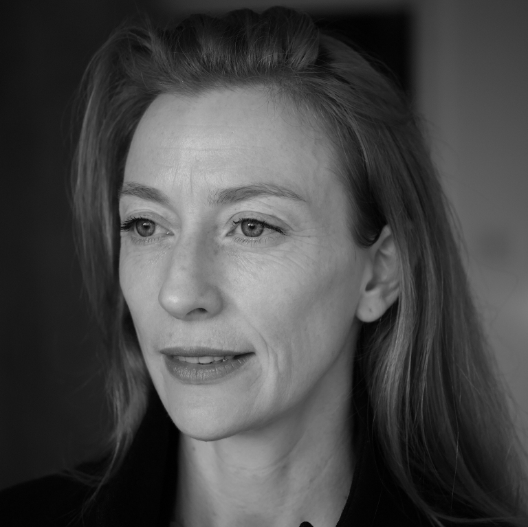 A woman with long hair looking into the distance.