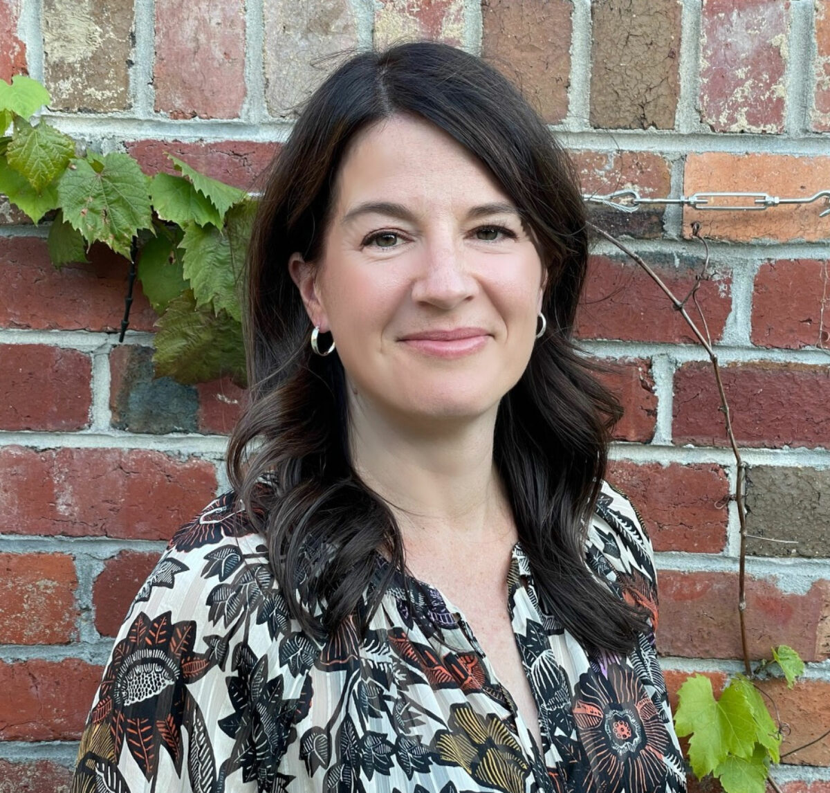 A person smiling with wavy hair