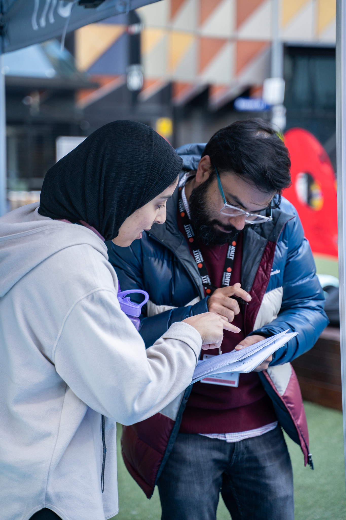 A student and staff member talk over some paperwork during international student week.