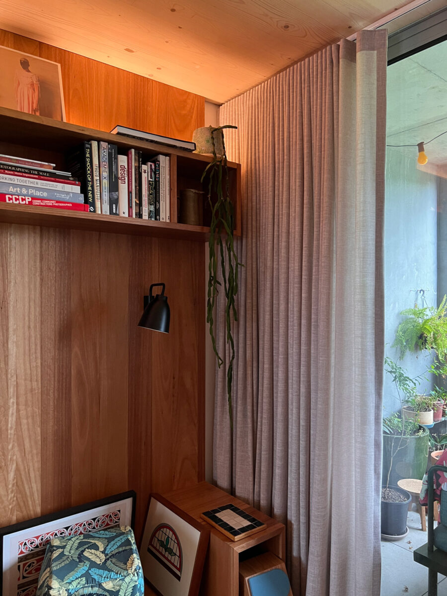 A photo of a living room corner showing bookshelf and timber ceiling.
