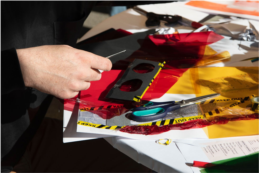 Hands moving over yellow, red and black materials.