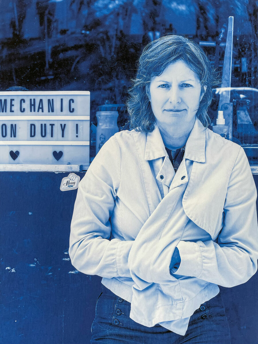 A woman stares at the camera with her hands in her pockets.