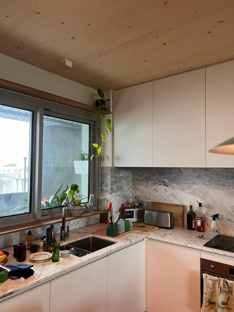 A kitchen with timber ceilings and white cupboards.