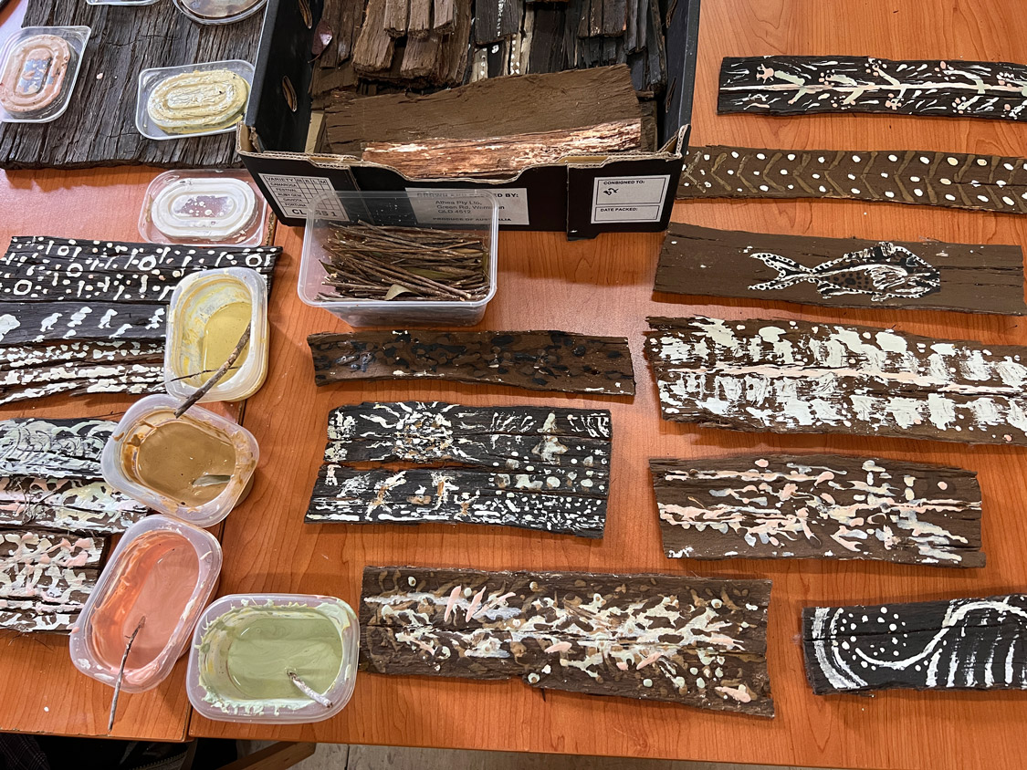 Pots of clay paint and painted bark.