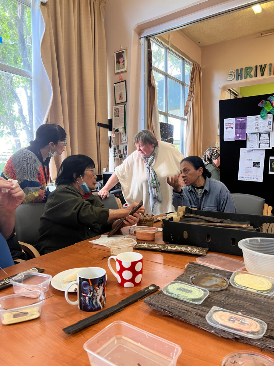 Four people in conversation at a workshop table.