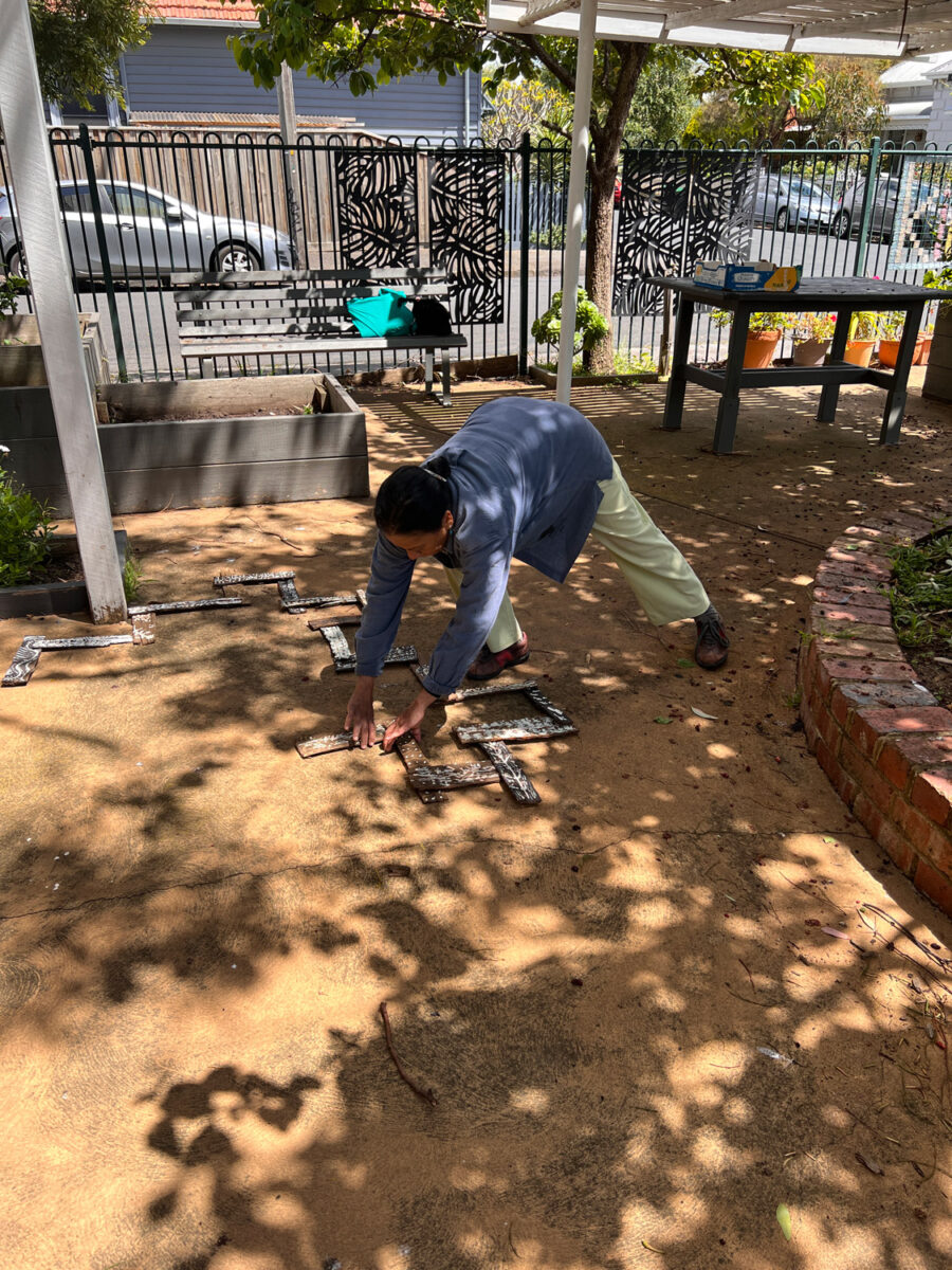 Varuni placing the bark in an arrangement outside under a tree.