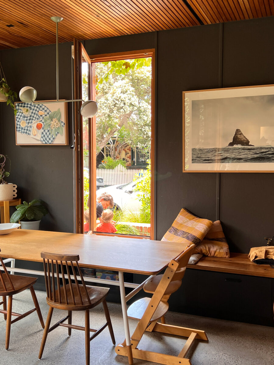 A father and young daughter in the front yard, viewed through a window.