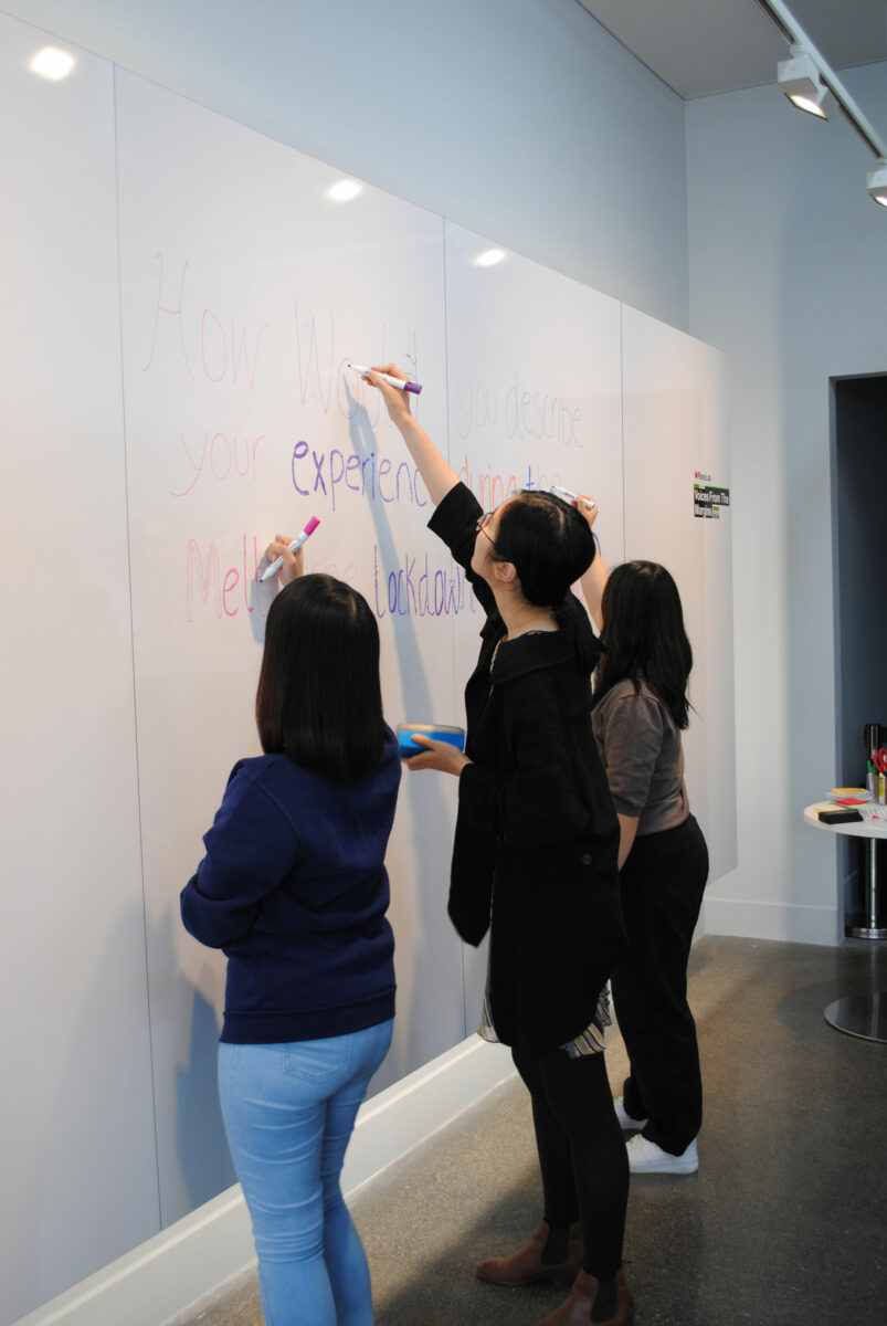 3 people standing at the whiteboard.