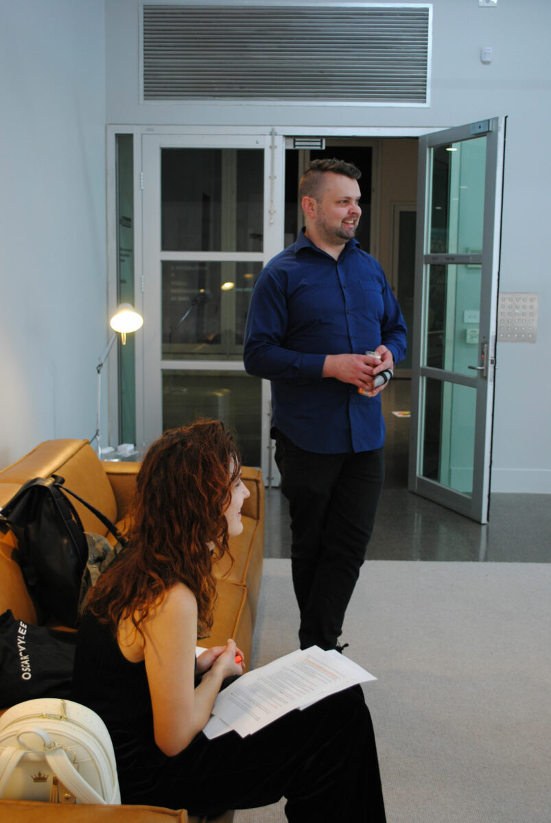 Two smiling figures stare off camera.