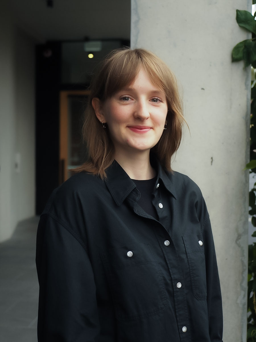 Woman smiling with collared shirt.