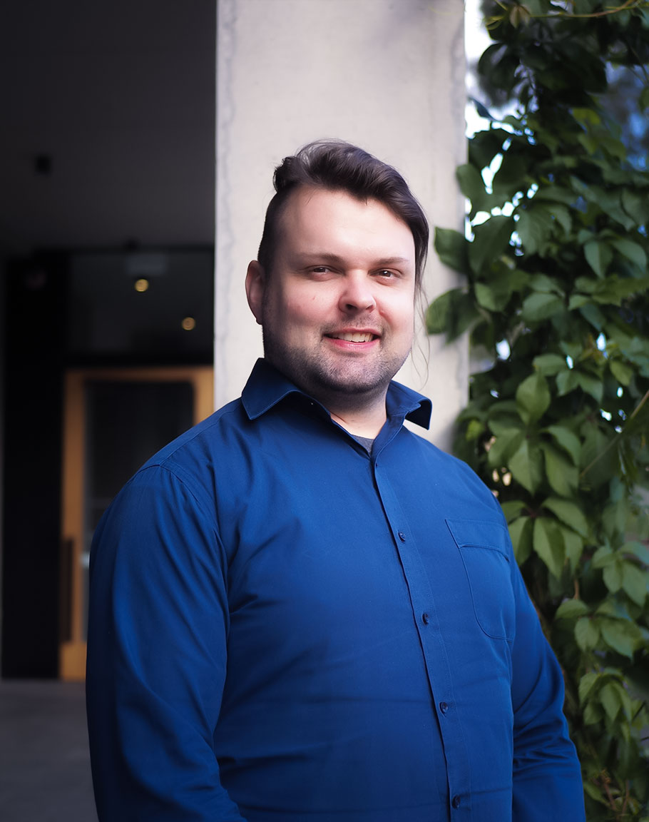 Man smiling with collared shirt on.